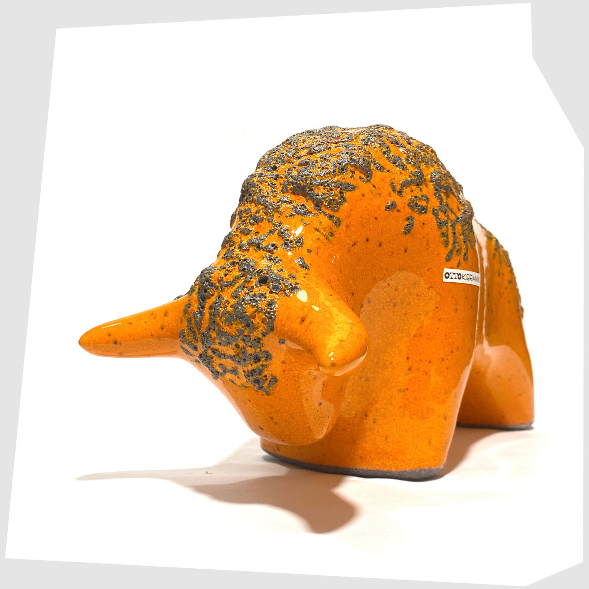 Front of the Otto Keramik Bull in Orange Fat Lava Glaze, shown on a white background