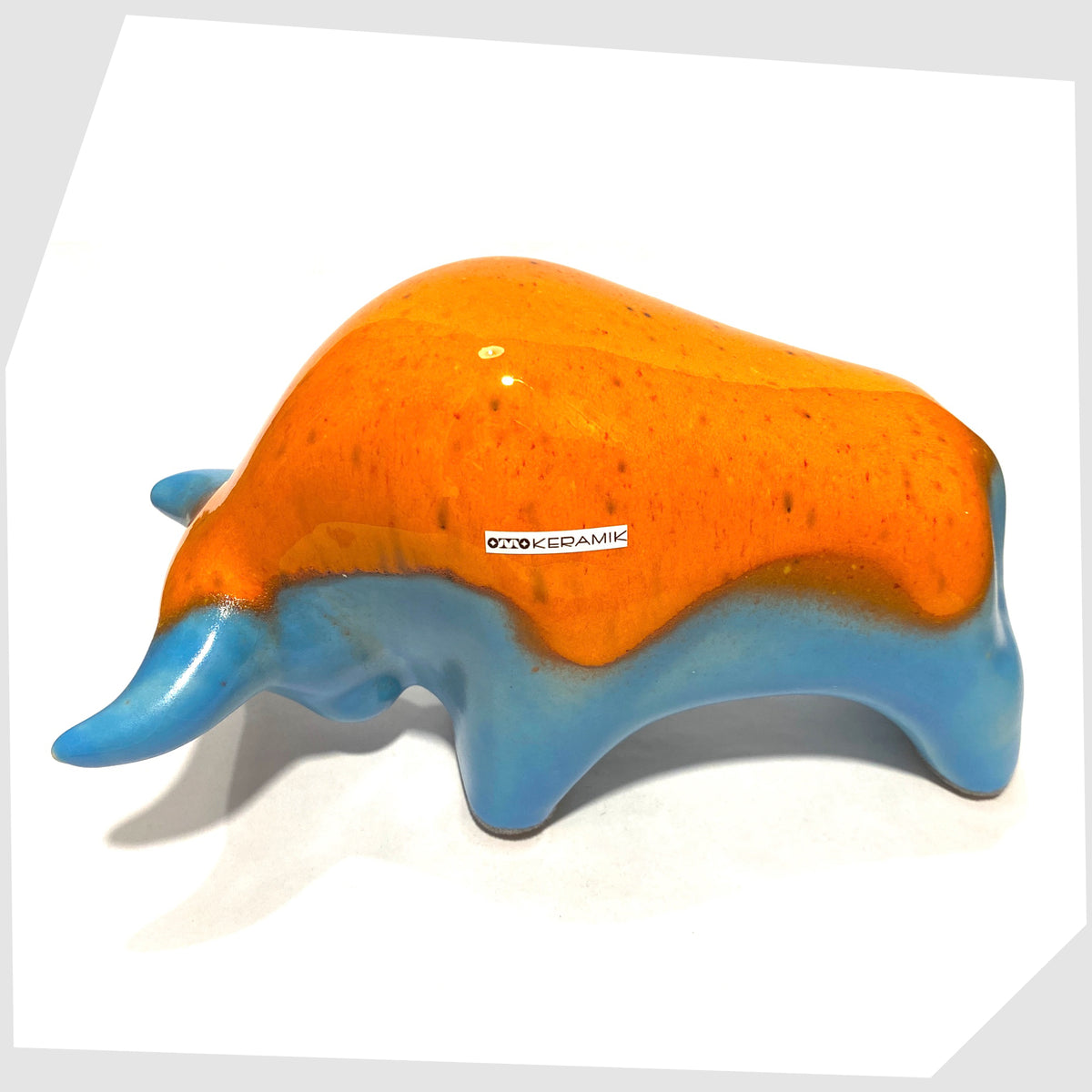 Back of the Otto Keramik Ceramic Bull ornament in orange over blue glaze, shown on a white background