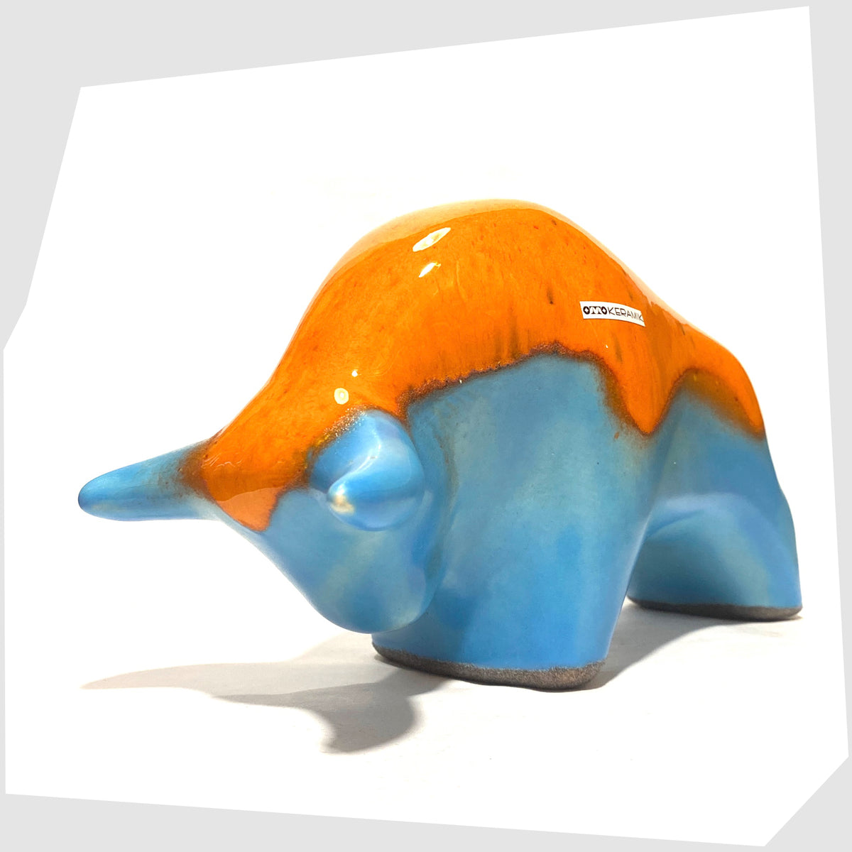 Otto Keramik Ceramic Bull in vibrant orange over blue glaze, shown on a white background