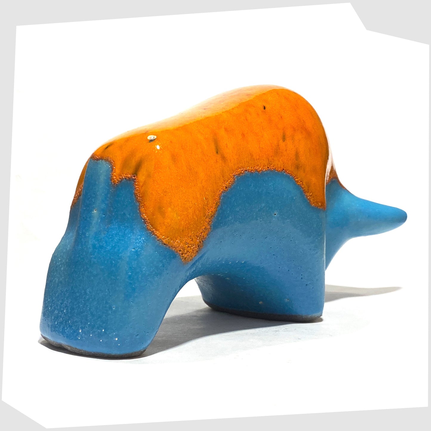 Rear angle of the Otto Keramik Ceramic Bull in Orange Over Blue glaze, shown on a white background
