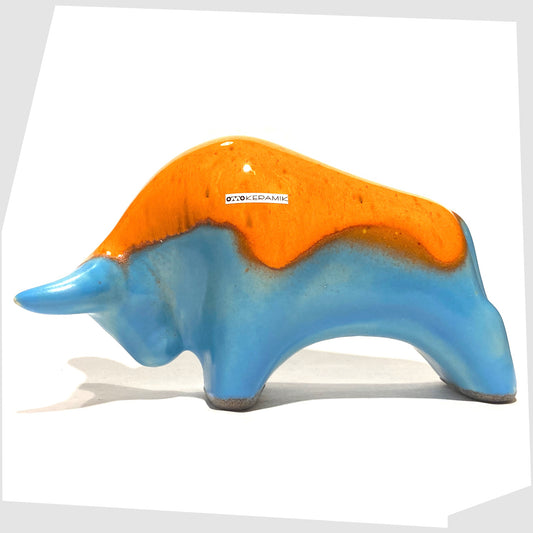 Otto Keramik Bull in orange over blue glaze, shown on a white background