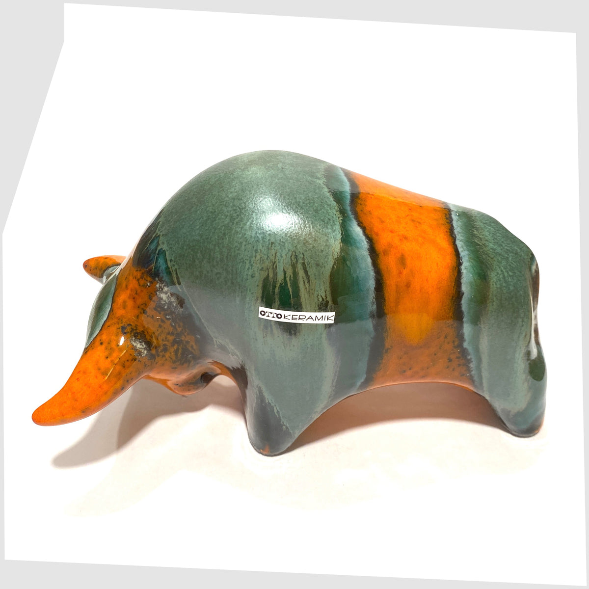 Back of the Otto Keramik Bull in Peru Glaze of orange with sea green bands, shown on a white background