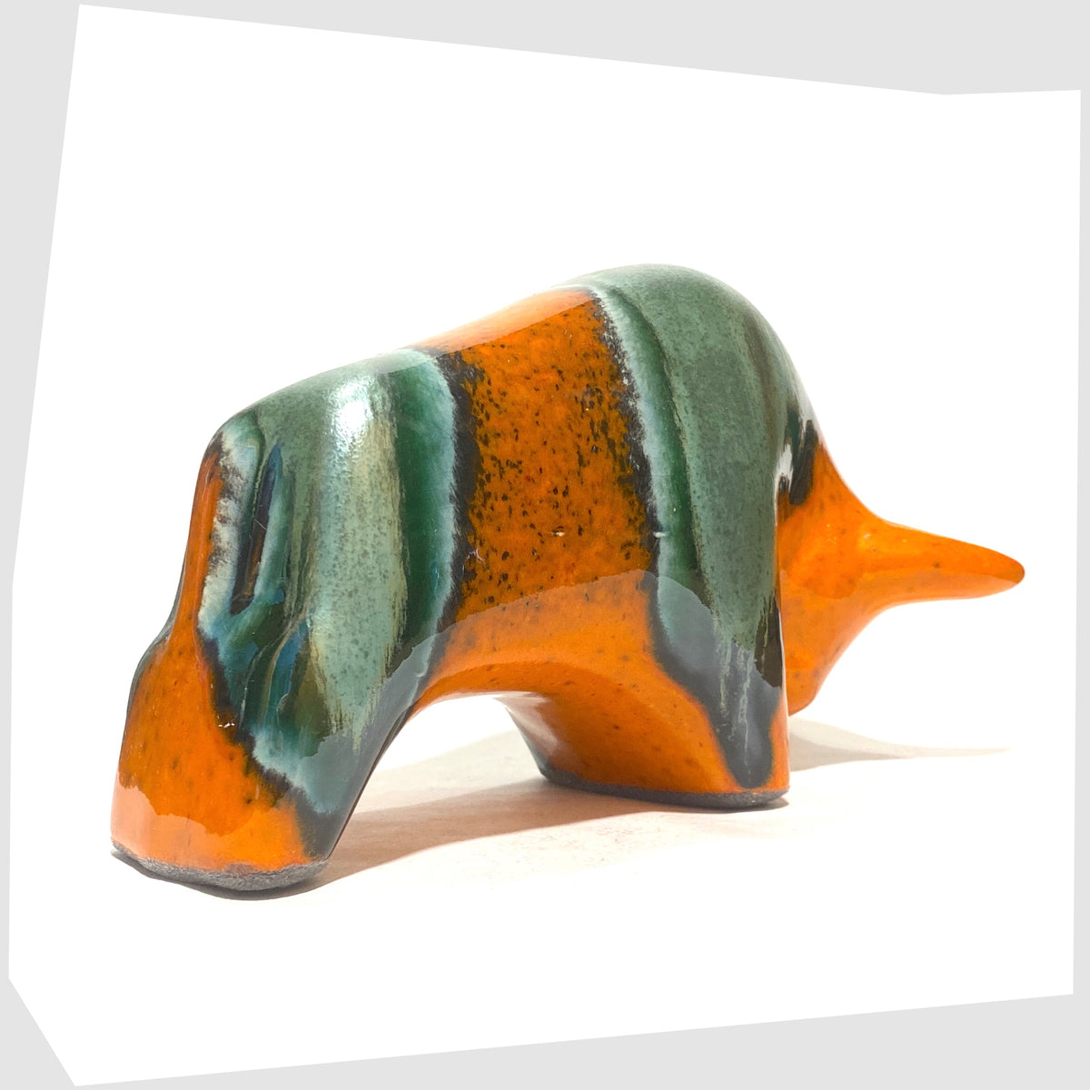 Rear of the Otto Keramik Bull in Peru Glaze of orange with sea green bands, shown on a white background