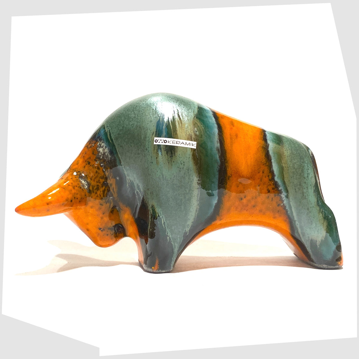 Otto Keramik Bull in Peru Glaze of orange with sea green bands, shown on a white background
