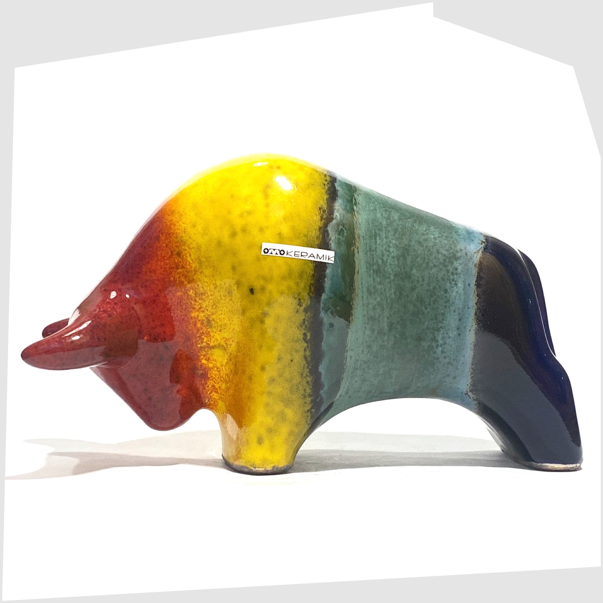 Otto Keramik ceramic bull in rainbow glaze of multicoloured stripes, shown on a white background
