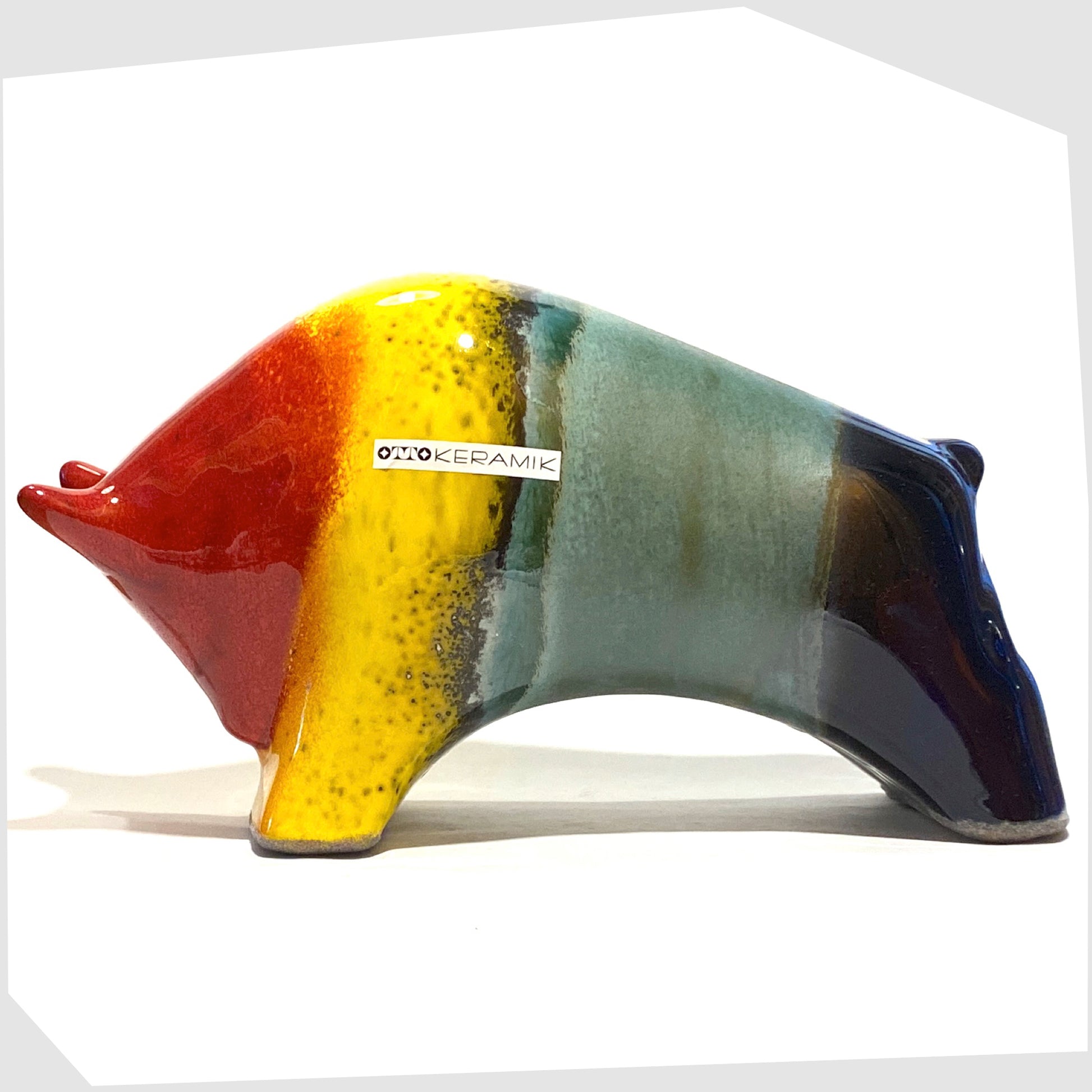 large otto keramik bull in multicoloured rainbow, glazed with stripes of red, yellow, green and navy