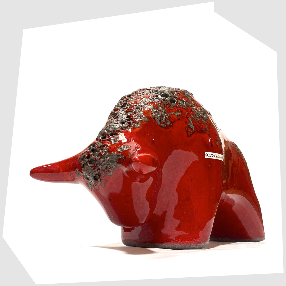 Horns on the Otto Keramik ceramic bull in red fat lava glaze, bull shaped sculpture in red with grey fat lava along the spine, shown on a white background