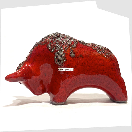 Otto Keramik ceramic bull in red fat lava glaze, bull shaped sculpture in red with grey fat lava along the spine, shown on a white background