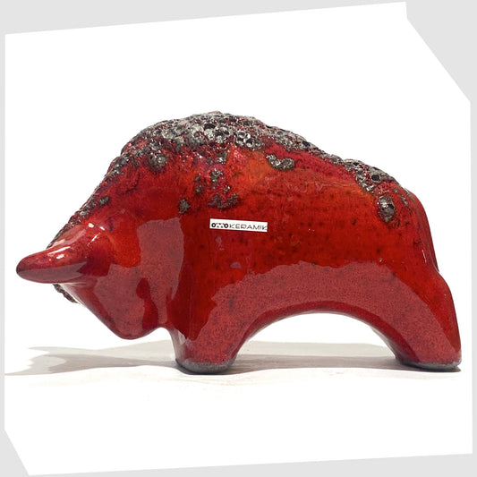 Otto Keramik ceramic bull in red fat lava glaze, bull shaped sculpture in red with grey fat lava along the spine, shown on a white background