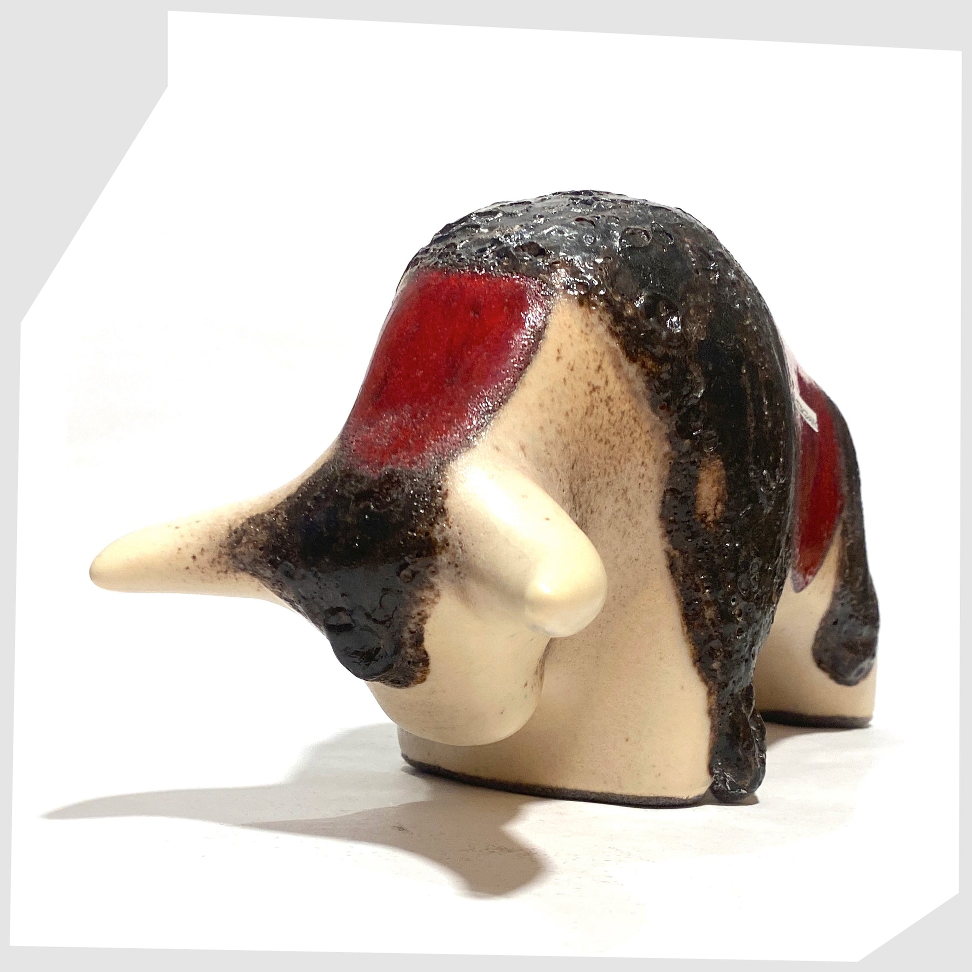 Front of the Otto Keramik ceramic bull in cream and red glaze with bands of thick fat lava, shown on a white background