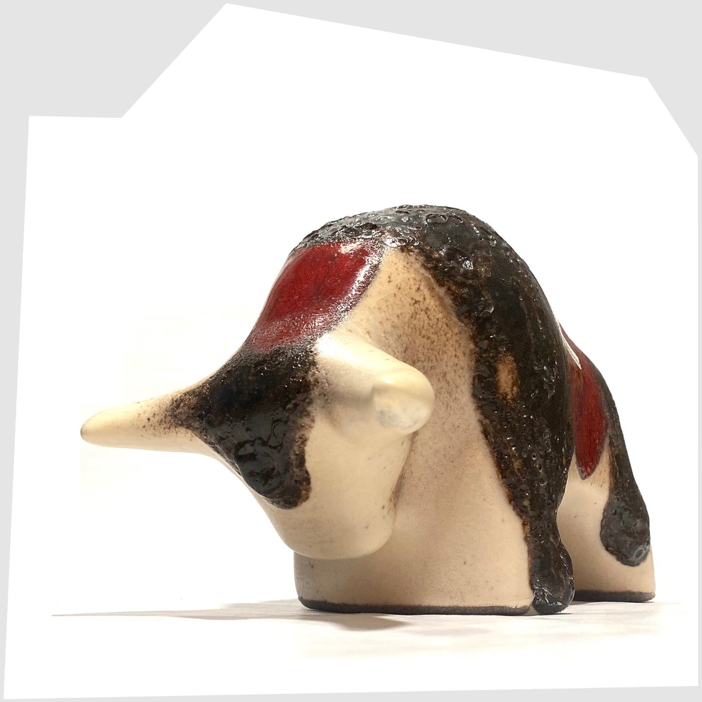 Front horns of the Otto Keramik ceramic bull in cream and red glaze with bands of thick fat lava, shown on a white background