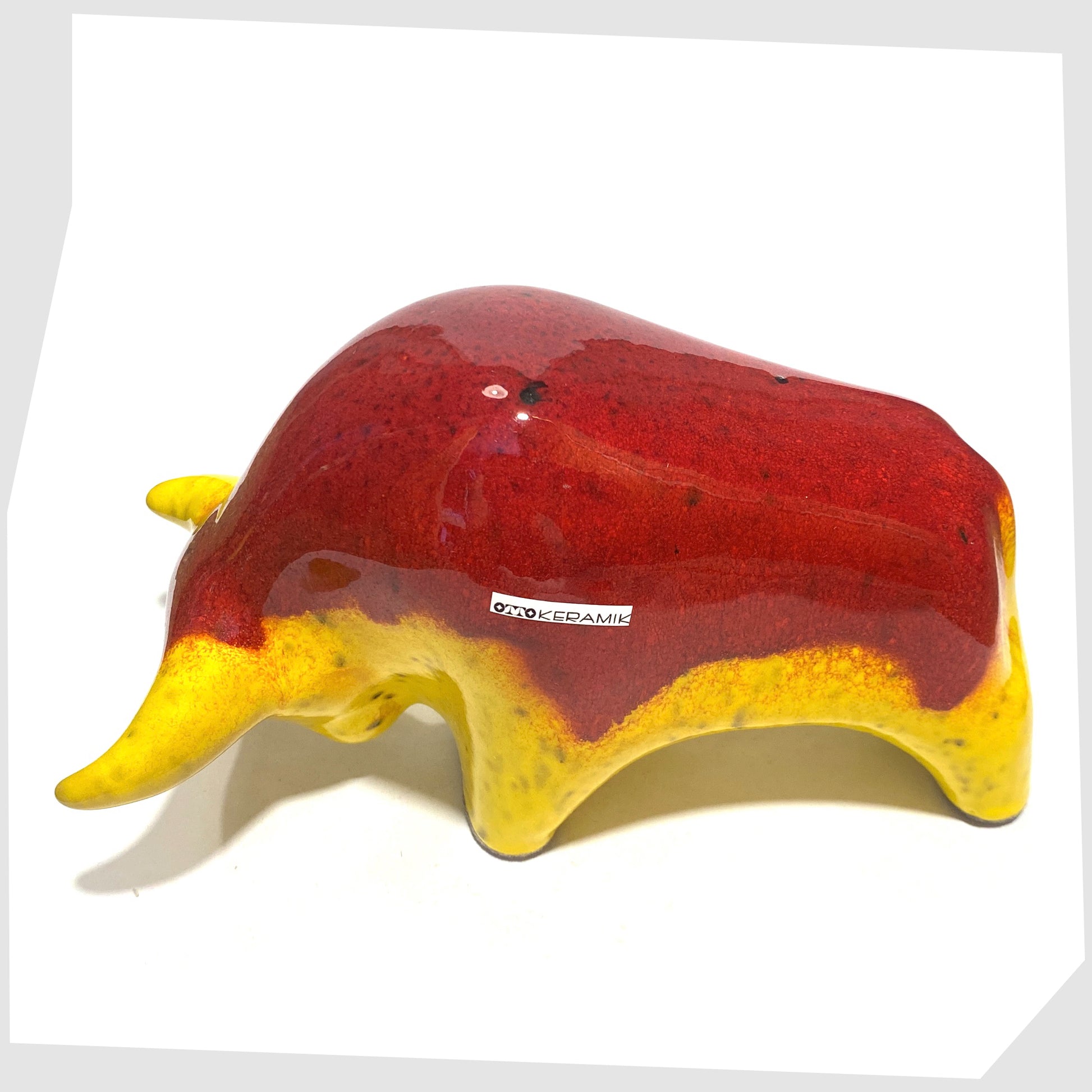 Back of the Otto Keramik Ceramic Bull in vibrant red over yellow glaze shown on a white background