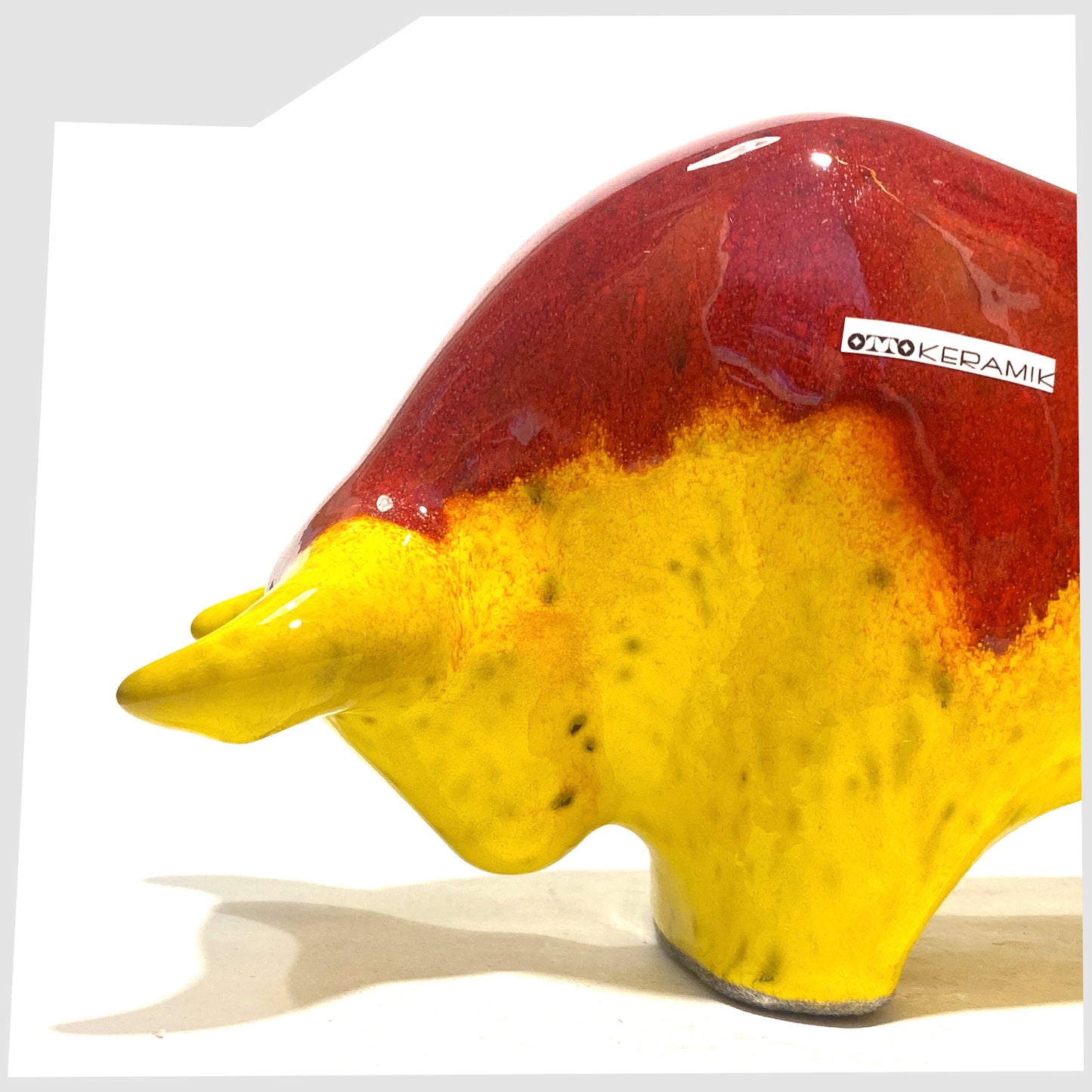 Close up of the Otto Keramik Ceramic Bull in vibrant red over yellow glaze shown on a white background