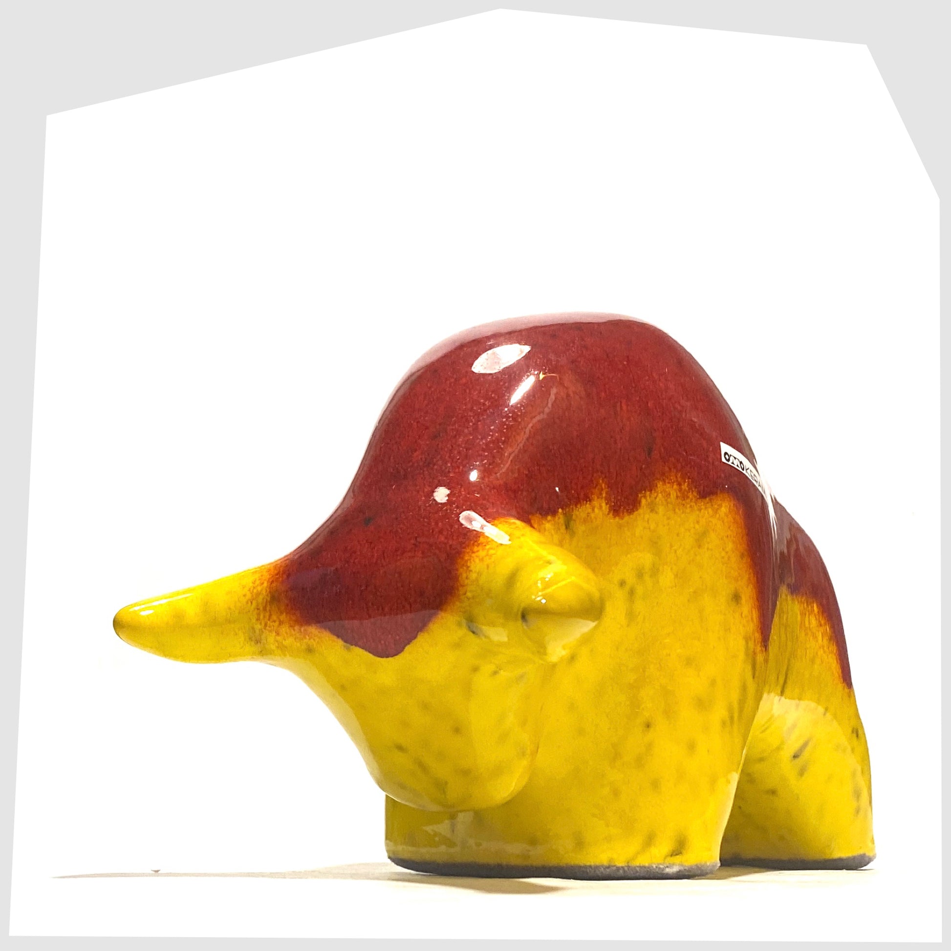 Front horns of the Otto Keramik Ceramic Bull in vibrant red over yellow glaze shown on a white background