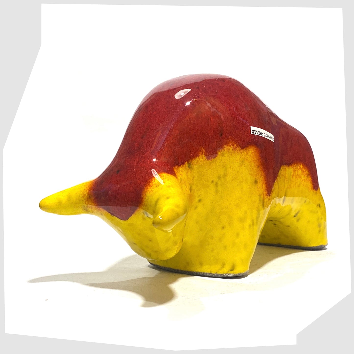 Front of the Otto Keramik Ceramic Bull in vibrant red over yellow glaze shown on a white background