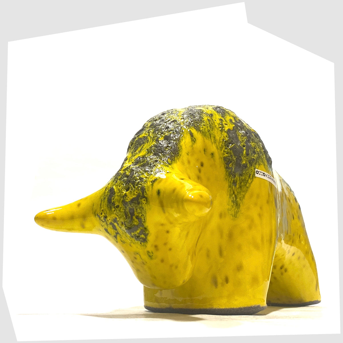 Front horns of the Otto Keramik Ceramic Bull in yellow with grey fat lava on the spine, shown on a white background
