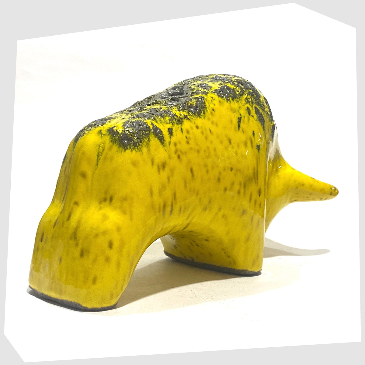 Rear of the Otto Keramik Ceramic Bull in yellow with grey fat lava on the spine, shown on a white background