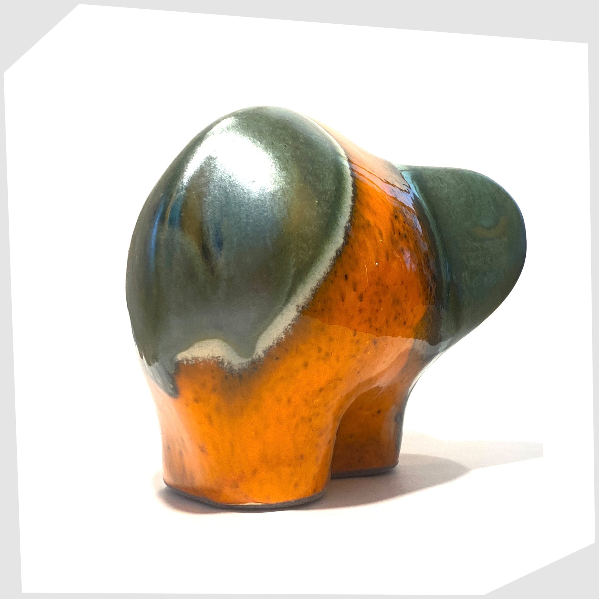 rear of the otto keramik ceramic elephant in peru glaze of vibrant orange and sea green stripes