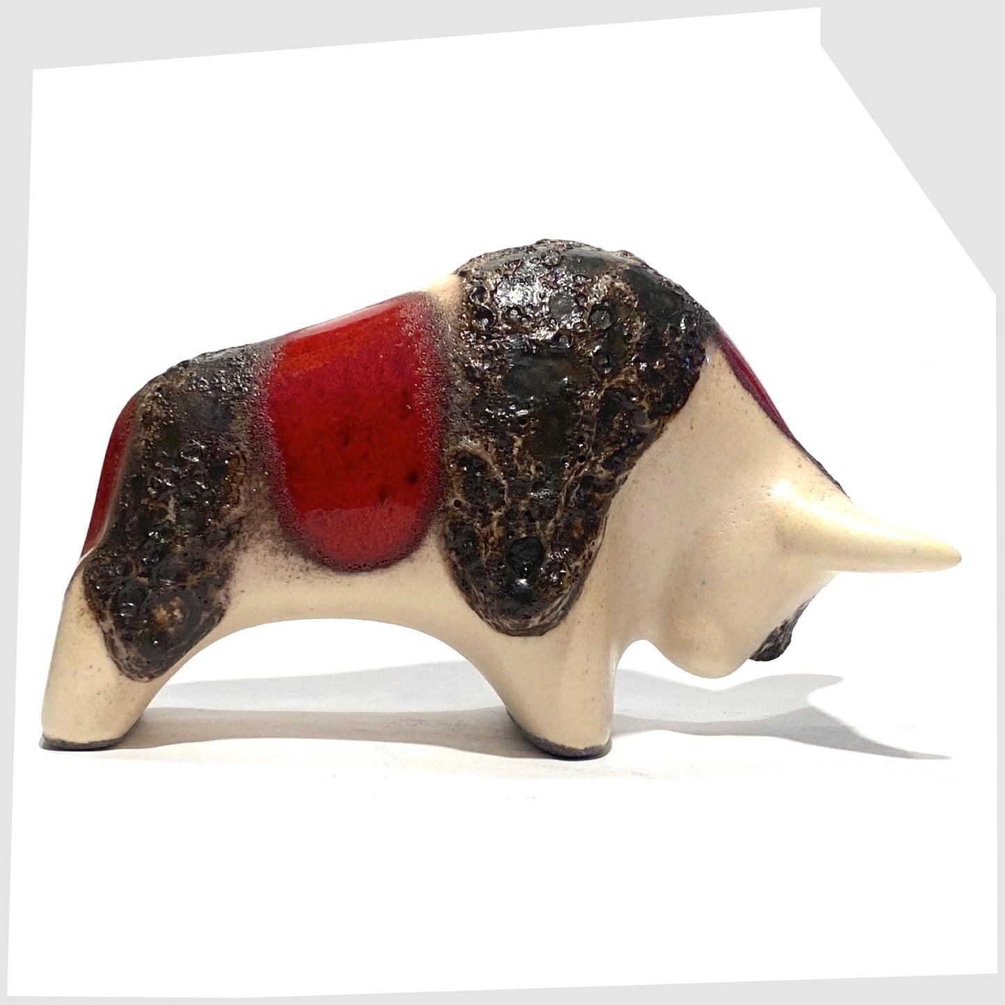 hand-crafted otto keramik ceramic bull shaped ornament in the red garnet glaze with stripes of deep fat lava