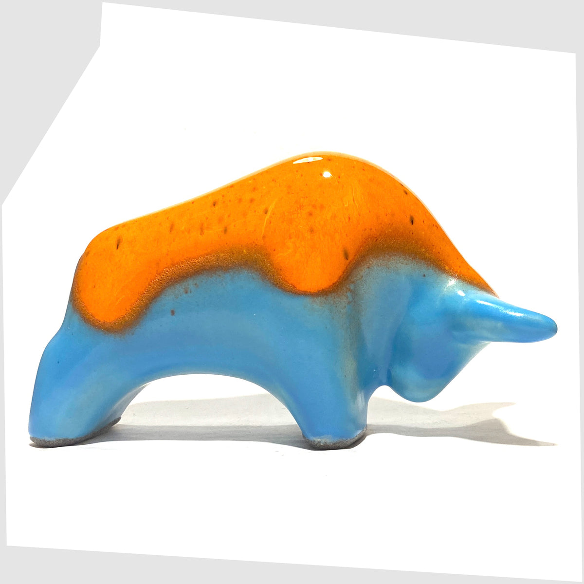 West German Pottery-style Otto Keramik Bull in orange over blue glaze, shown on a white background