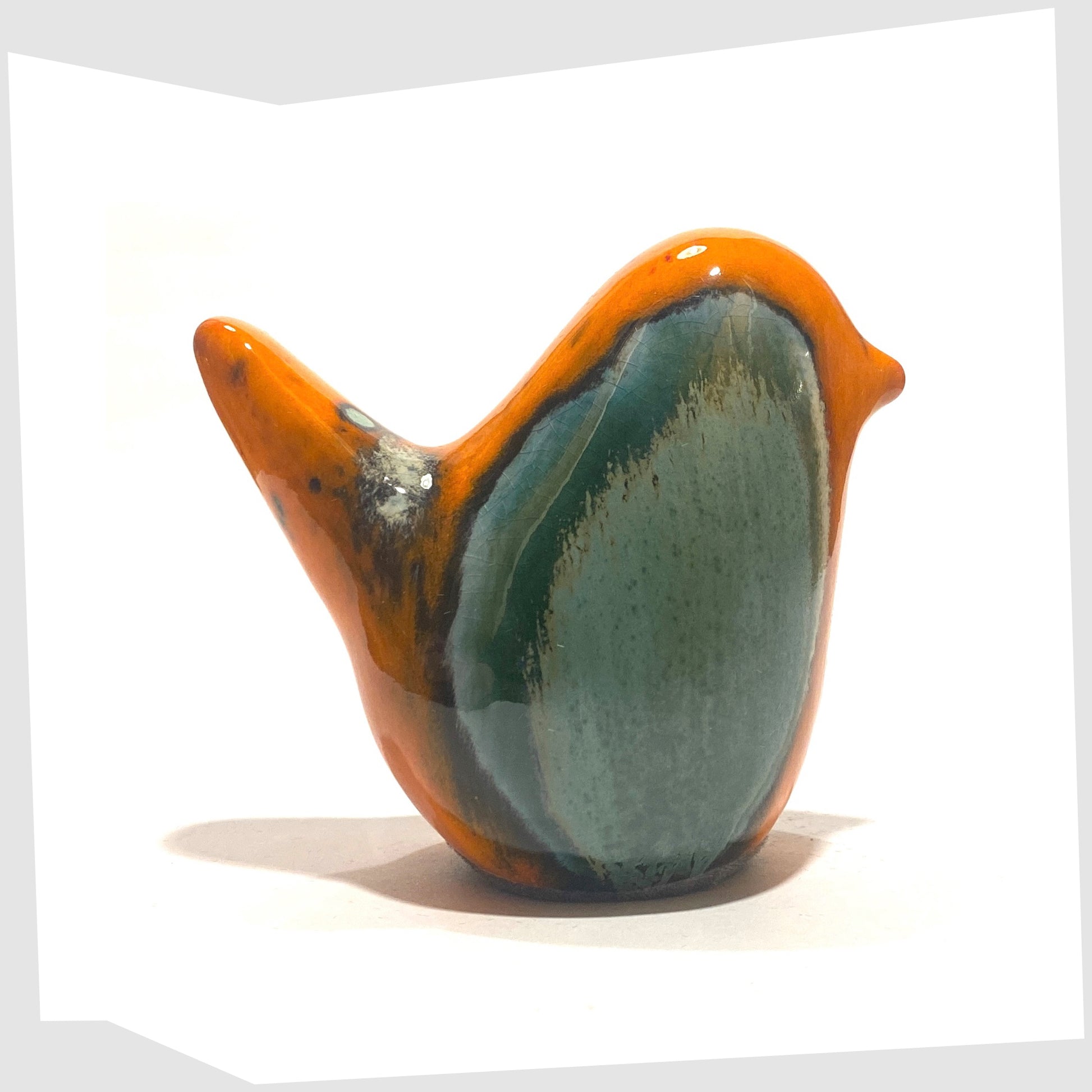 West German Pottery-style Otto Keramik Ceramic Bird in Peru glaze of orange with sea green drip glaze, shown on a white background