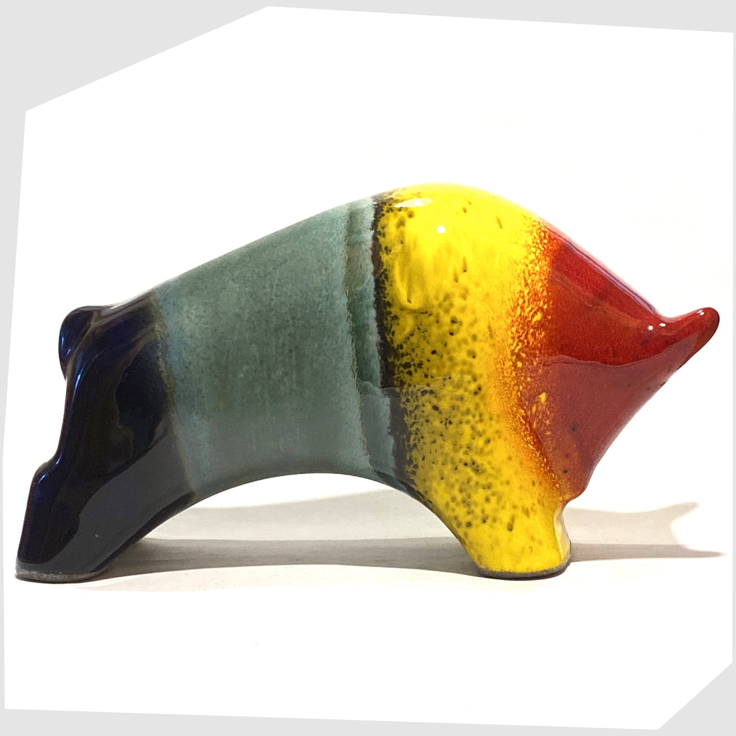 large otto keramik bull in multicoloured rainbow, glazed with stripes of red, yellow, green and navy