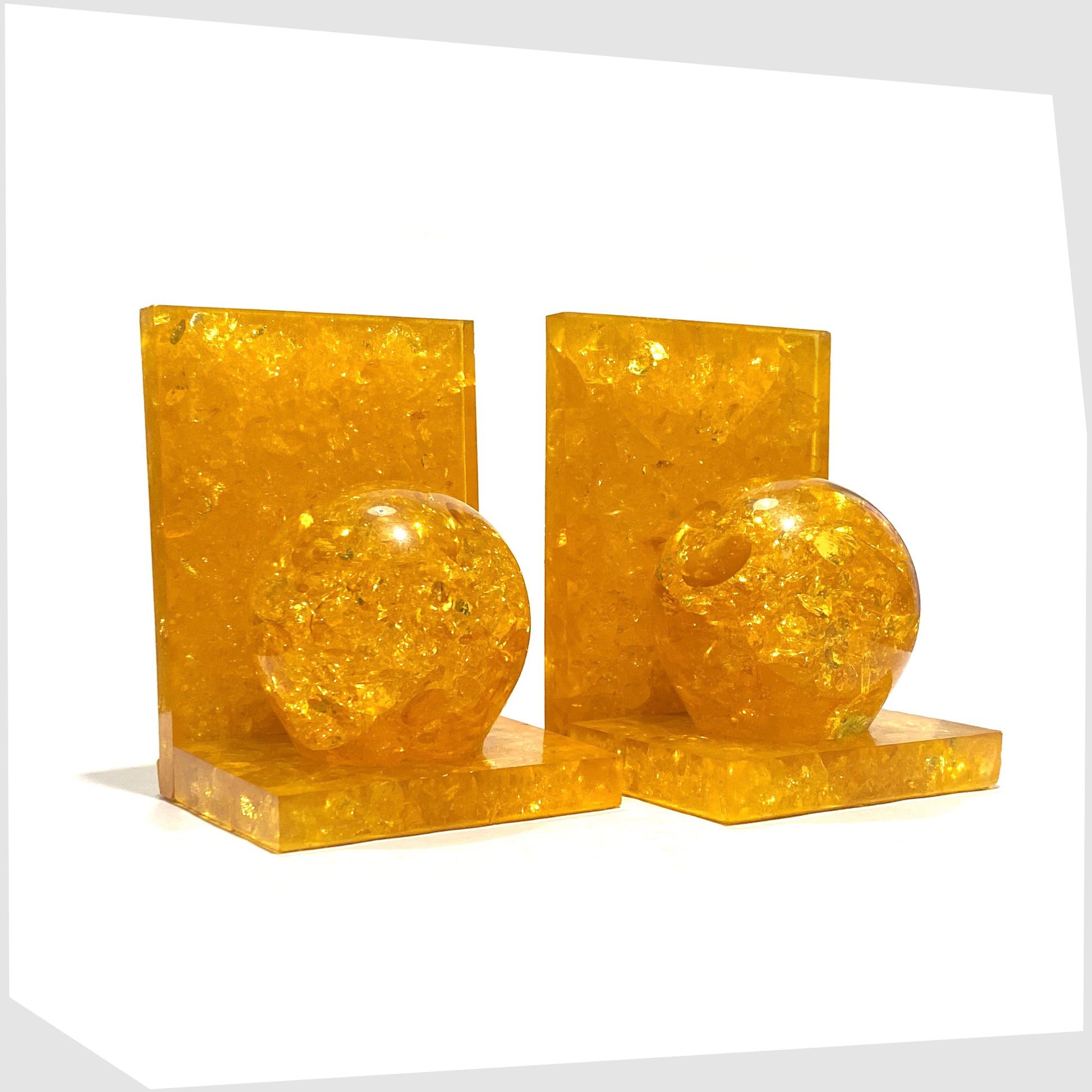 Pair of mid-century modern Shattaline Bookends in orange resin, L shaped bookends with circular ornament