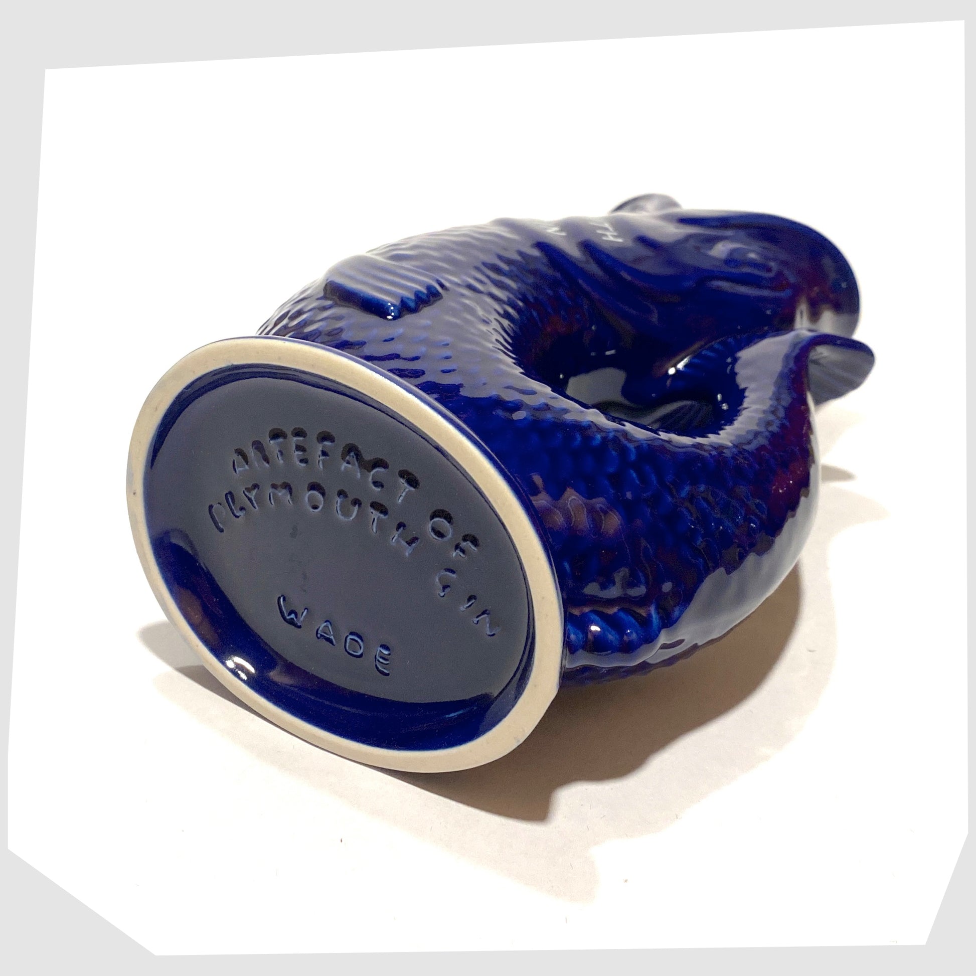 base of the artefact of wade ceramics, plymouth gin gluggle jug in cobalt blue glaze with white text