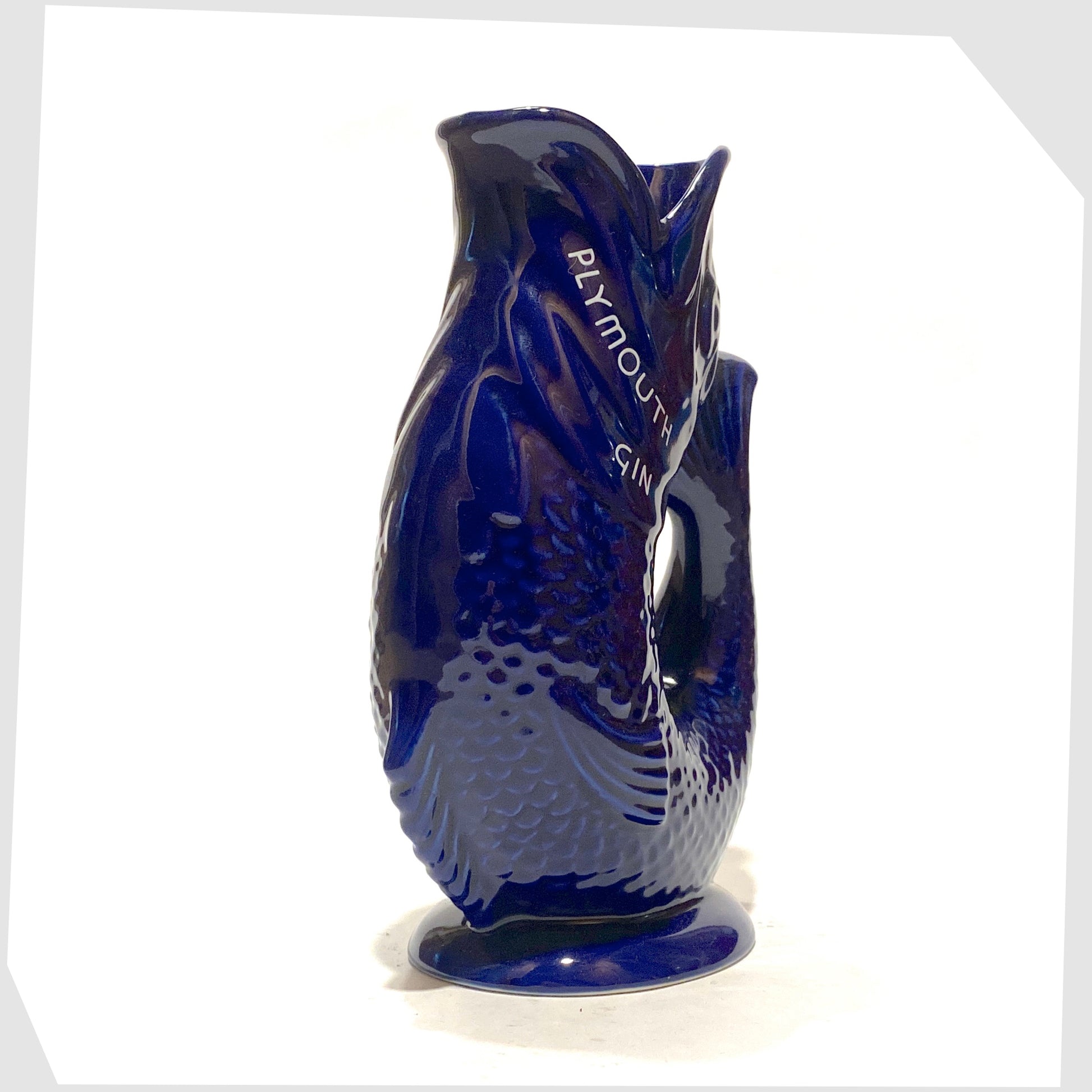 front of the artefact of wade ceramics, plymouth gin gluggle jug in cobalt blue glaze with white text