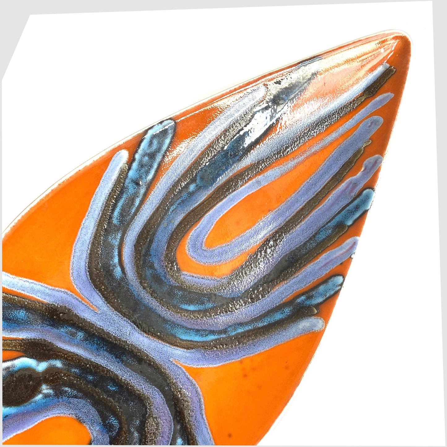 close up of the Poole Pottery Delphis Spear Dish by Margaret Anderson in a fiery orange glaze with radiating lines of blue and purple glaze