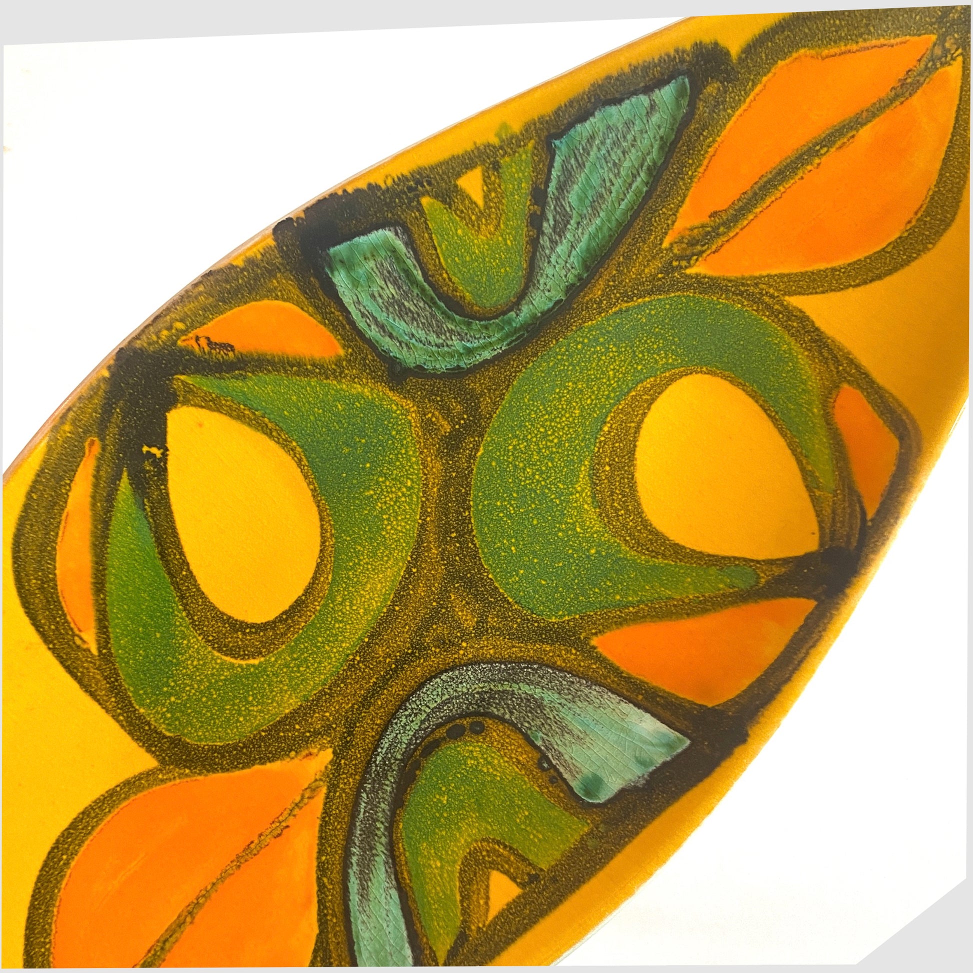 close up of the poole pottery delphis spear dish, shape 82, by Rosina St Clayre finished in a vibrant yellow glaze with free-forms of green, orange and turquoise
