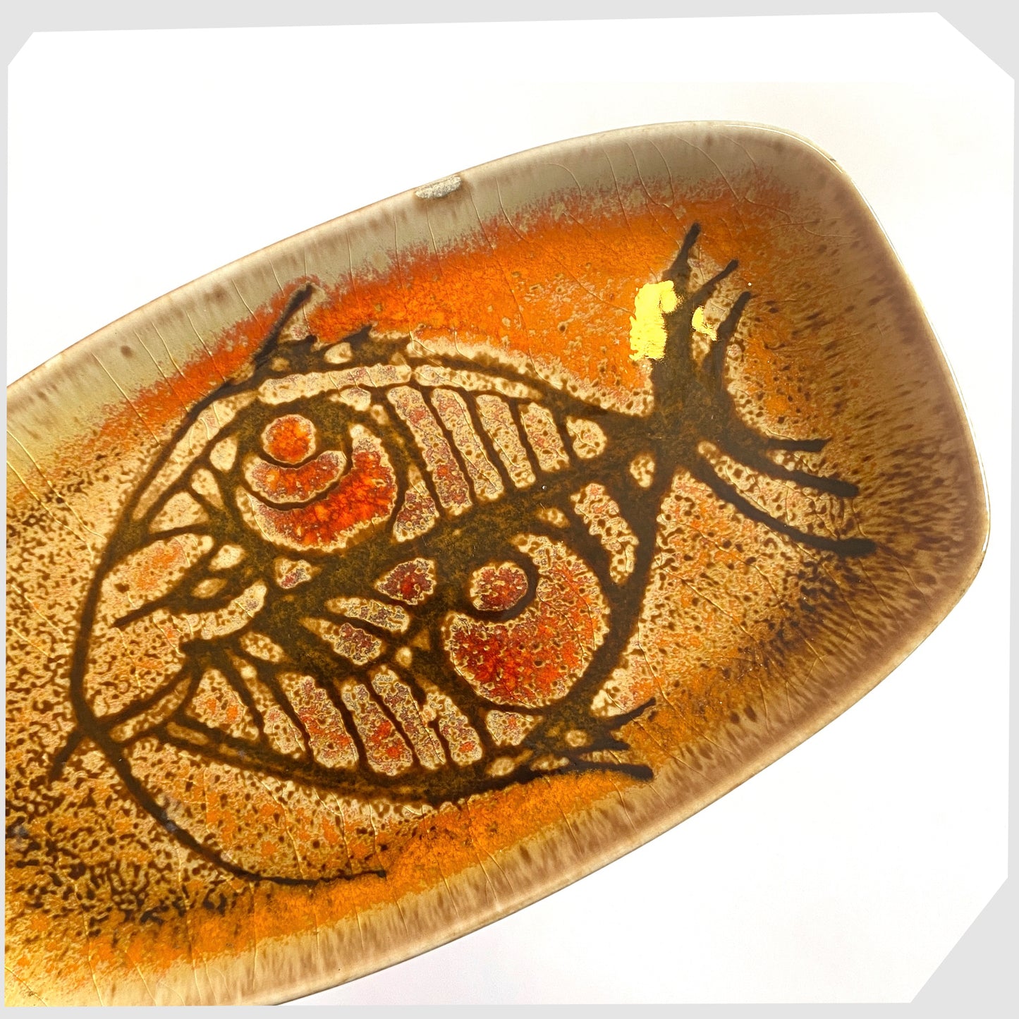 close up of the Poole Pottery Shape 361 Pin Dish by Diana Davis, finished in the Aegean colour way with a striking fish design 