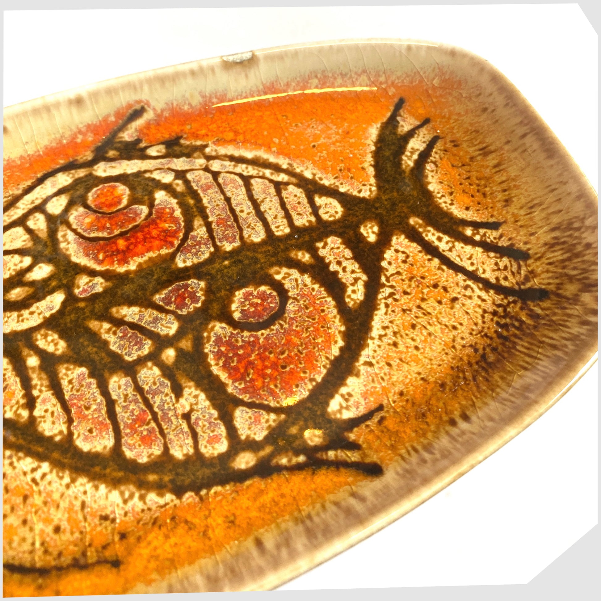 glazing close up of the Poole Pottery Shape 361 Pin Dish by Diana Davis, finished in the Aegean colour way with a striking fish design 