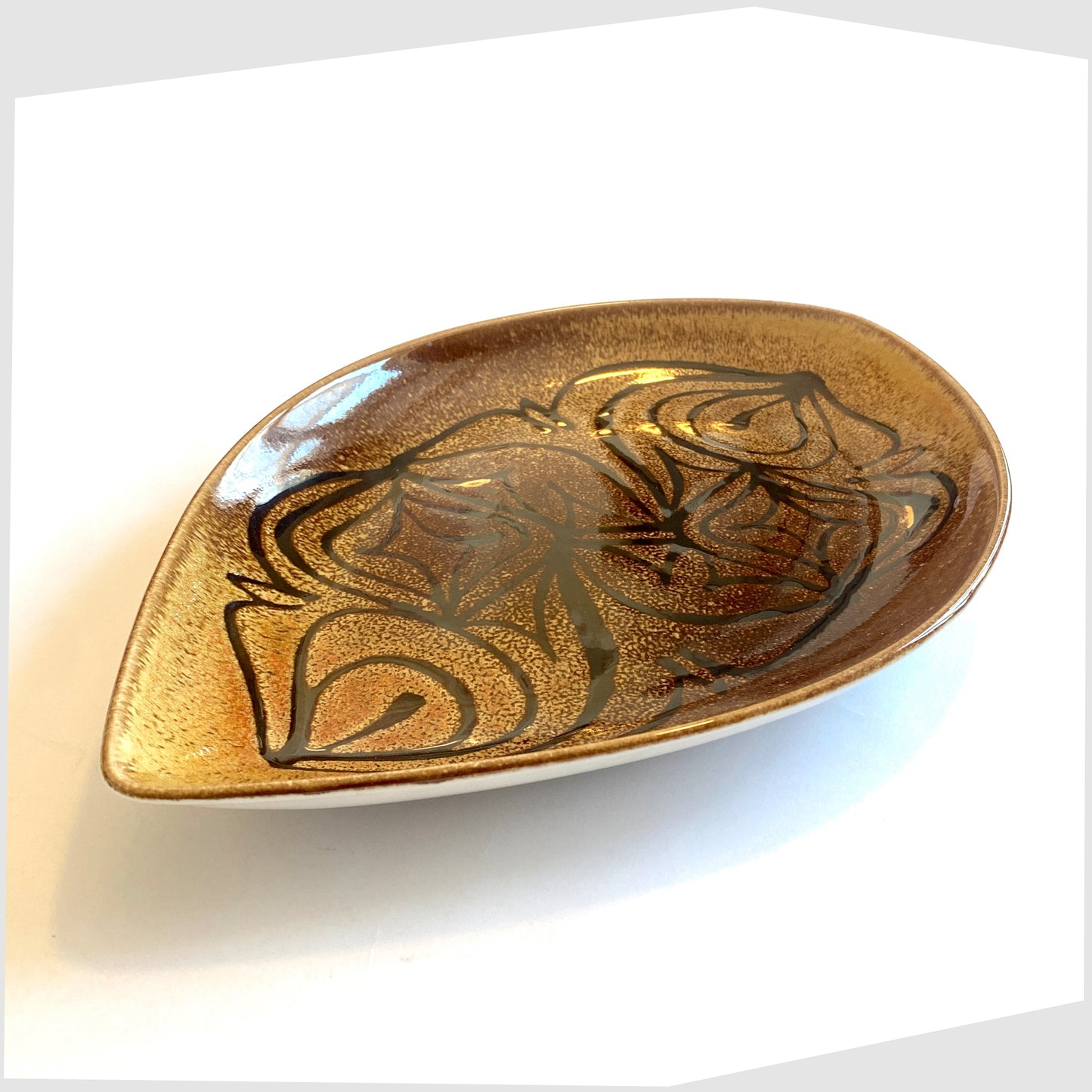 poole pottery aegean teardrop dish, shape 91, with black flowing lines on an amber and brown glaze
