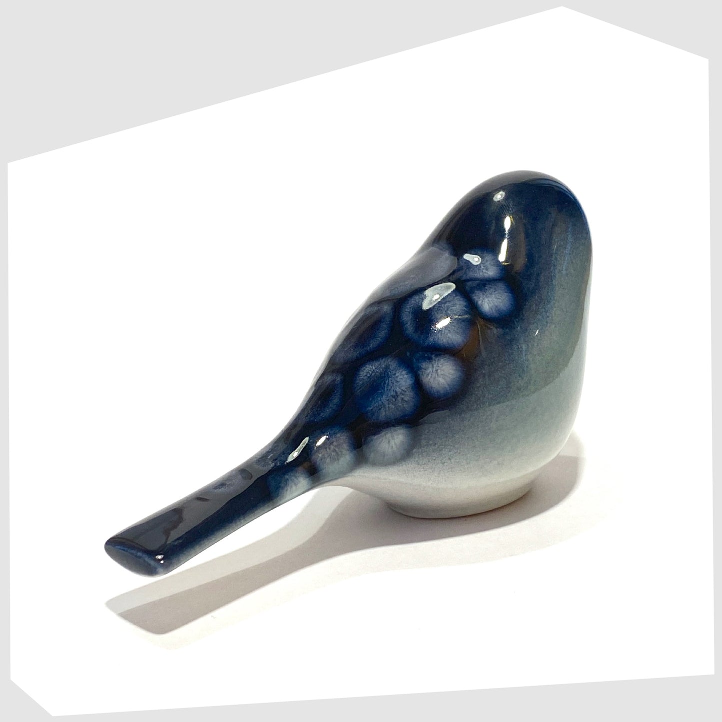 rear of the poole pottery perching bird ornament in ocean glaze of blue and white