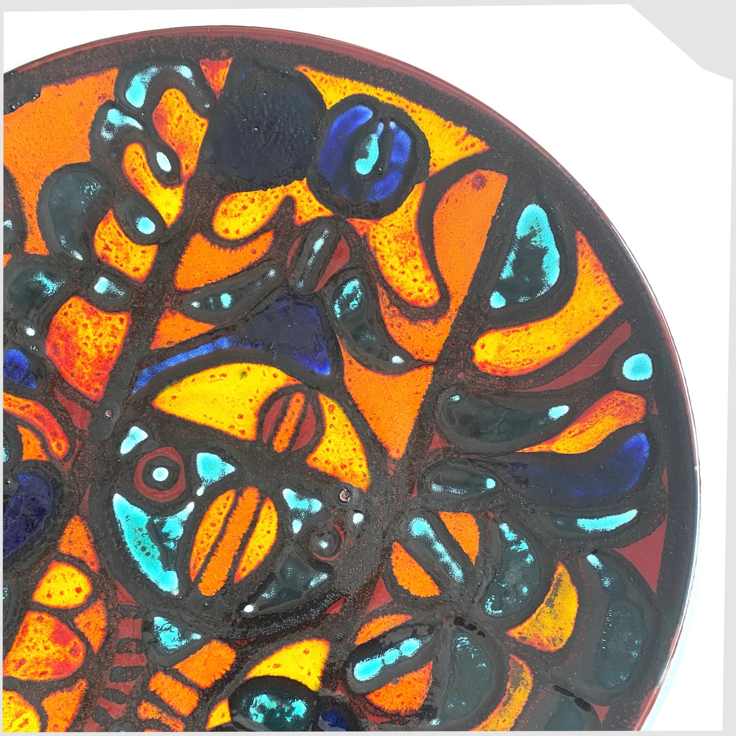 close up of the 14"  Poole Pottery Charger by Sally Murch, finished in a glaze of vivid orange, blue and green forms