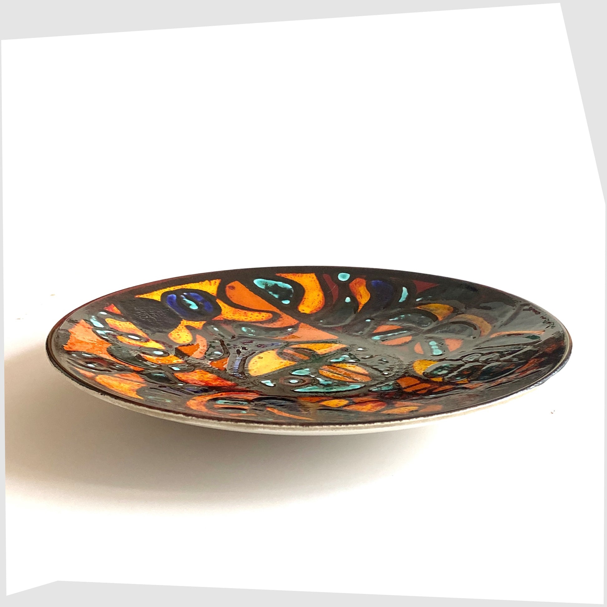 side profile of the 14"  Poole Pottery Charger by Sally Murch, finished in a glaze of vivid orange, blue and green forms