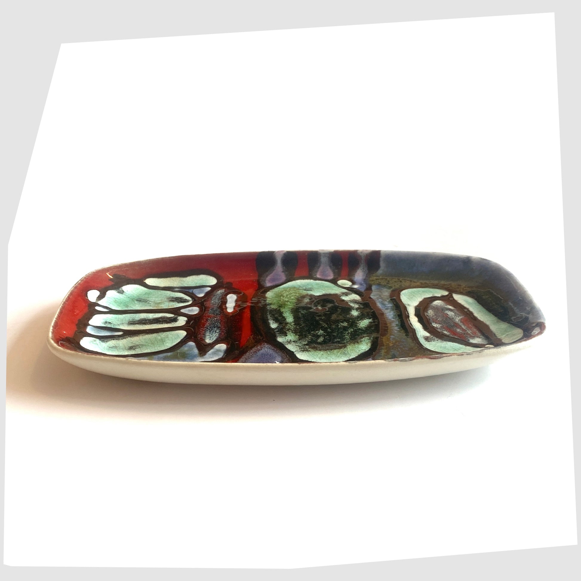 side profile of the Poole Pottery Delphis Pin Dish, Shape 361, by Angela Wyburgh in an artistic multicoloured glaze of red, blue and turquoise
