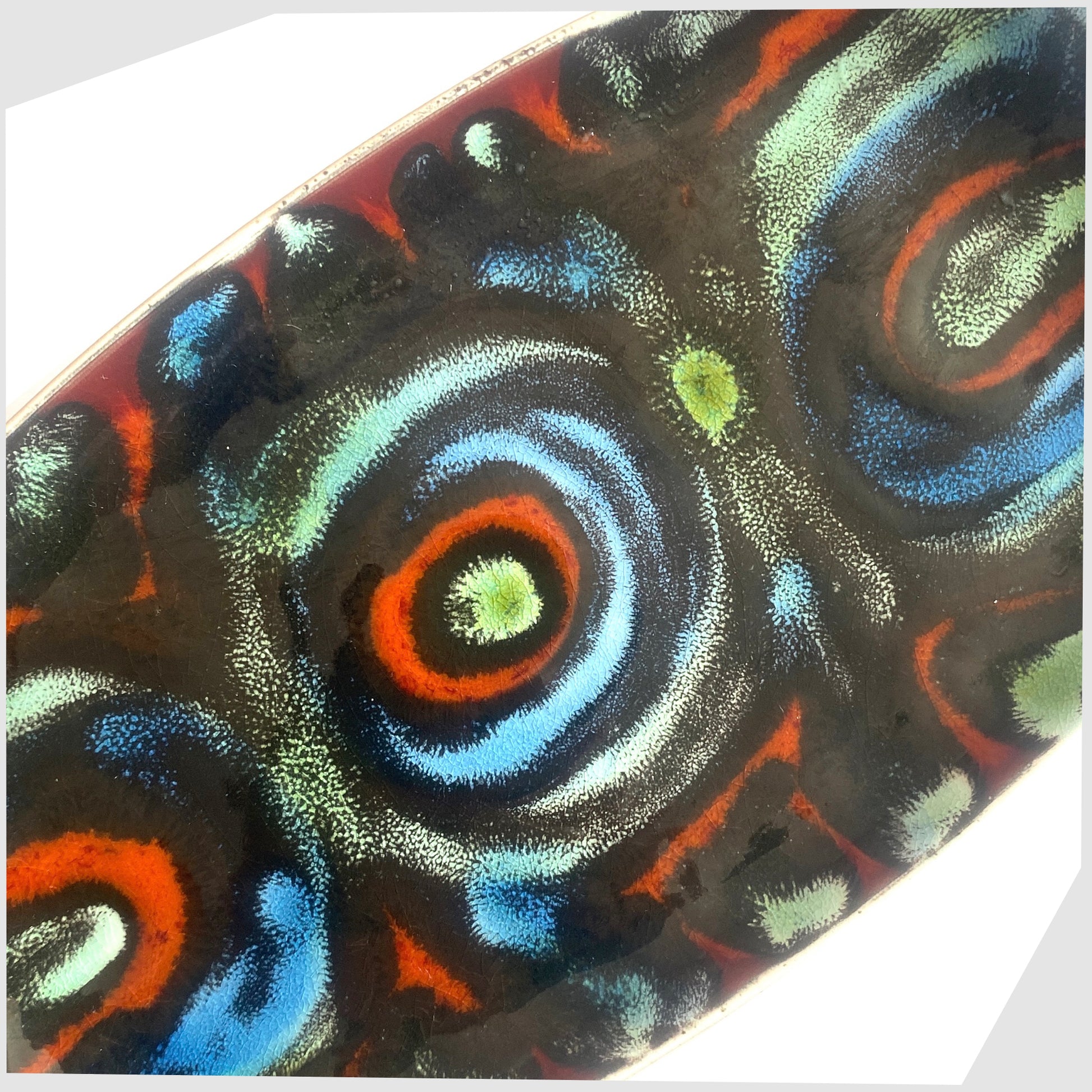 close up of the Poole Pottery Delphis Dish, Shape 361, by Jean Millership in a striking multicoloured glaze of radiating lines