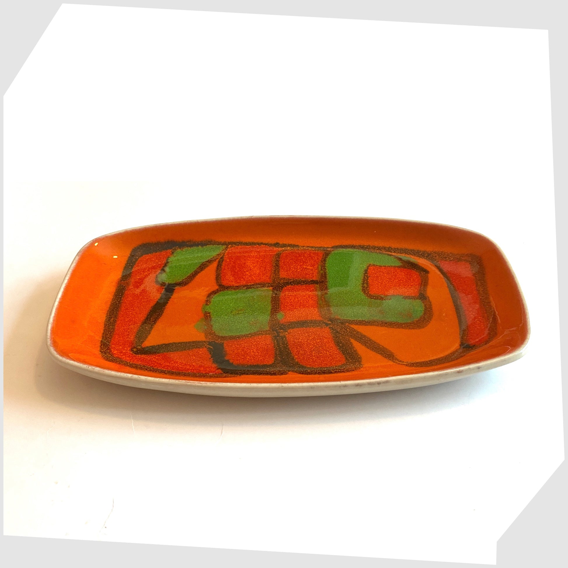 Early 1970s Poole Pottery Delphis Dish, Shape 61, by Gillian Taylor in a vivid orange glaze with forms of green and red, photographed on a white background