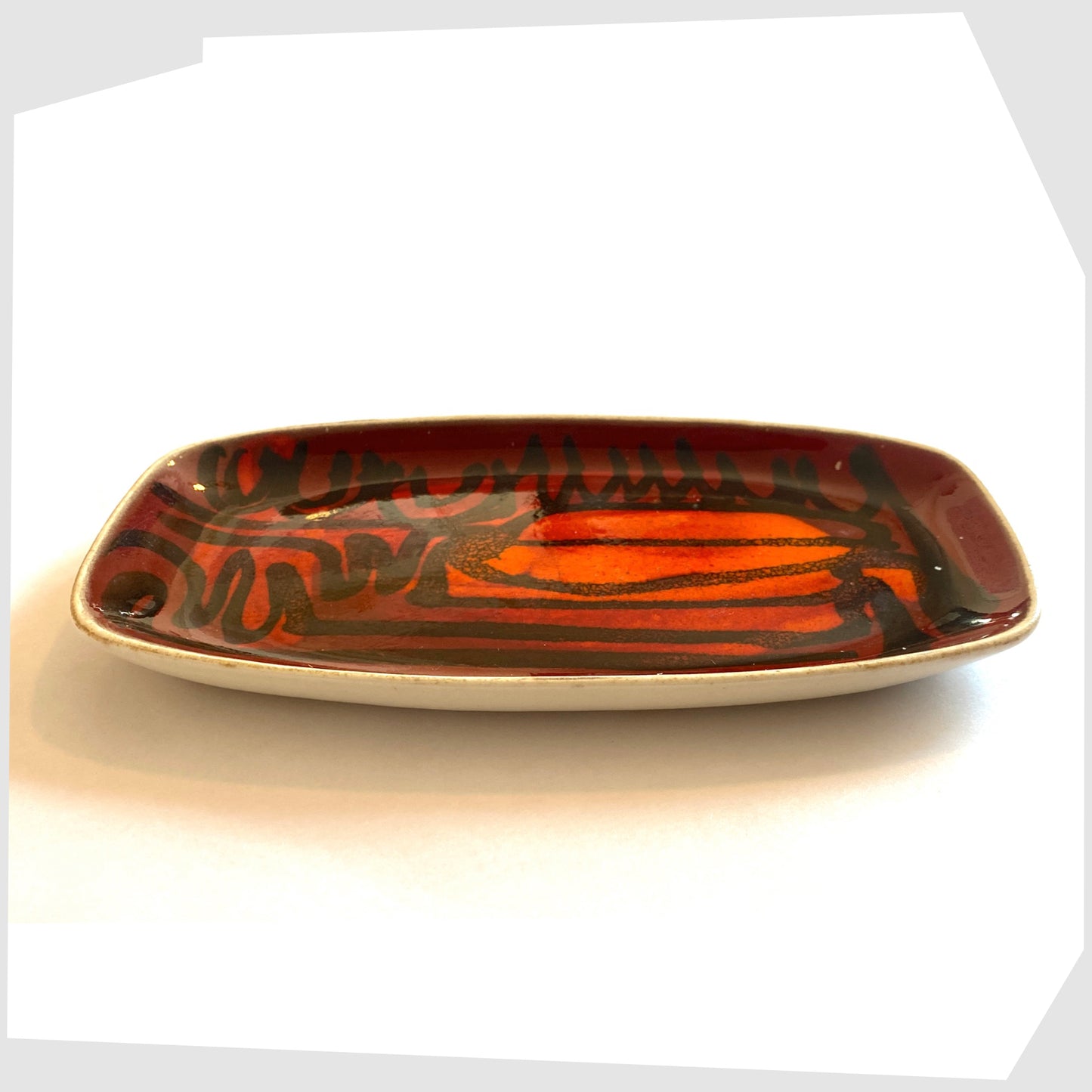 poole pottery delphis pin dish in a rich red and orange glaze with black flowing lines