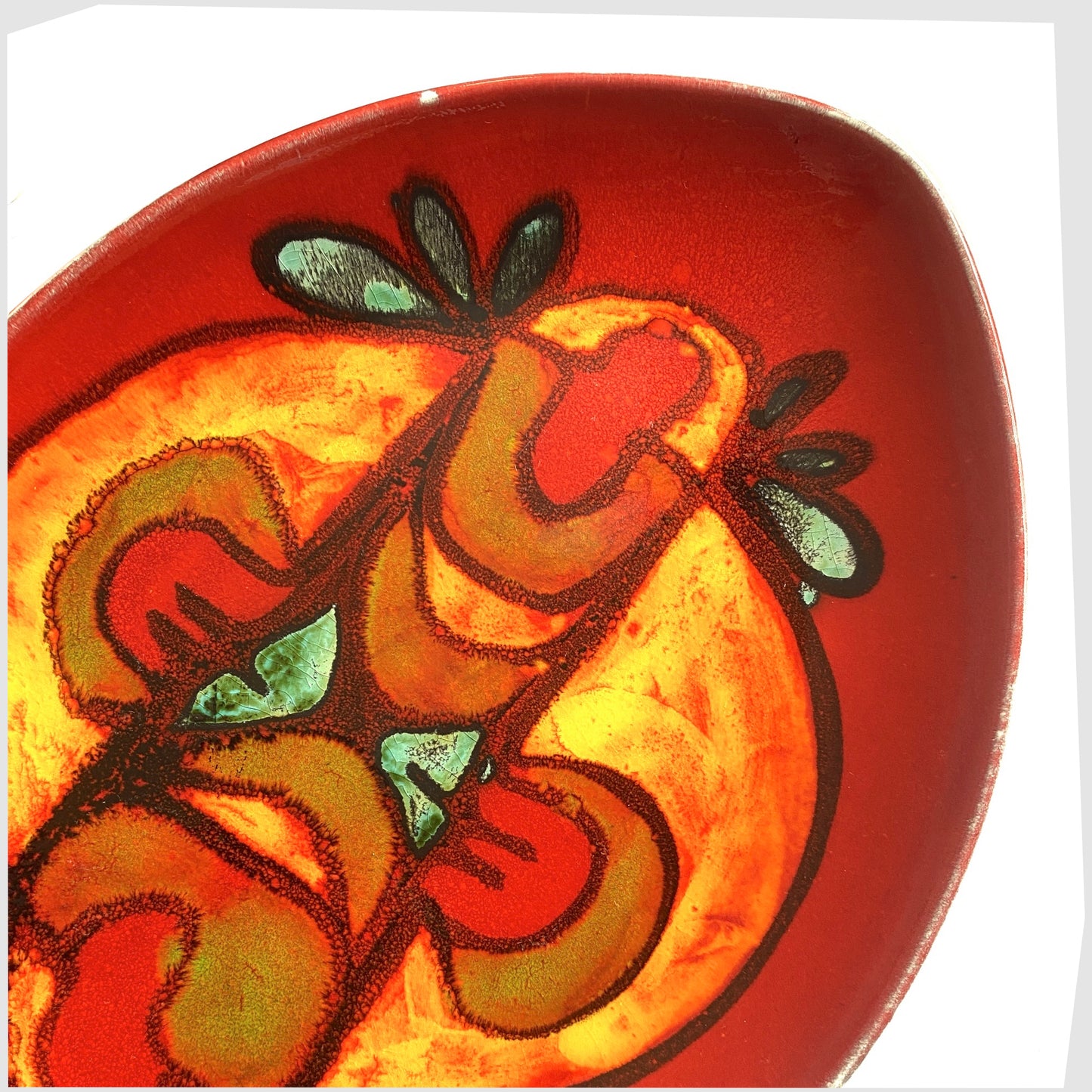 red delphis glaze on the poole pottery teardrop dish by andree fontana, glazed in a rich red with fluid forms of orange and green