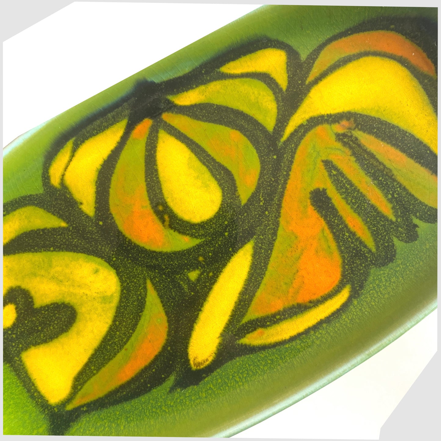 close up of the Poole Pottery Delphis Dish, Shape 361 by Cynthia Bennett in a green glaze with yellow and orange forms