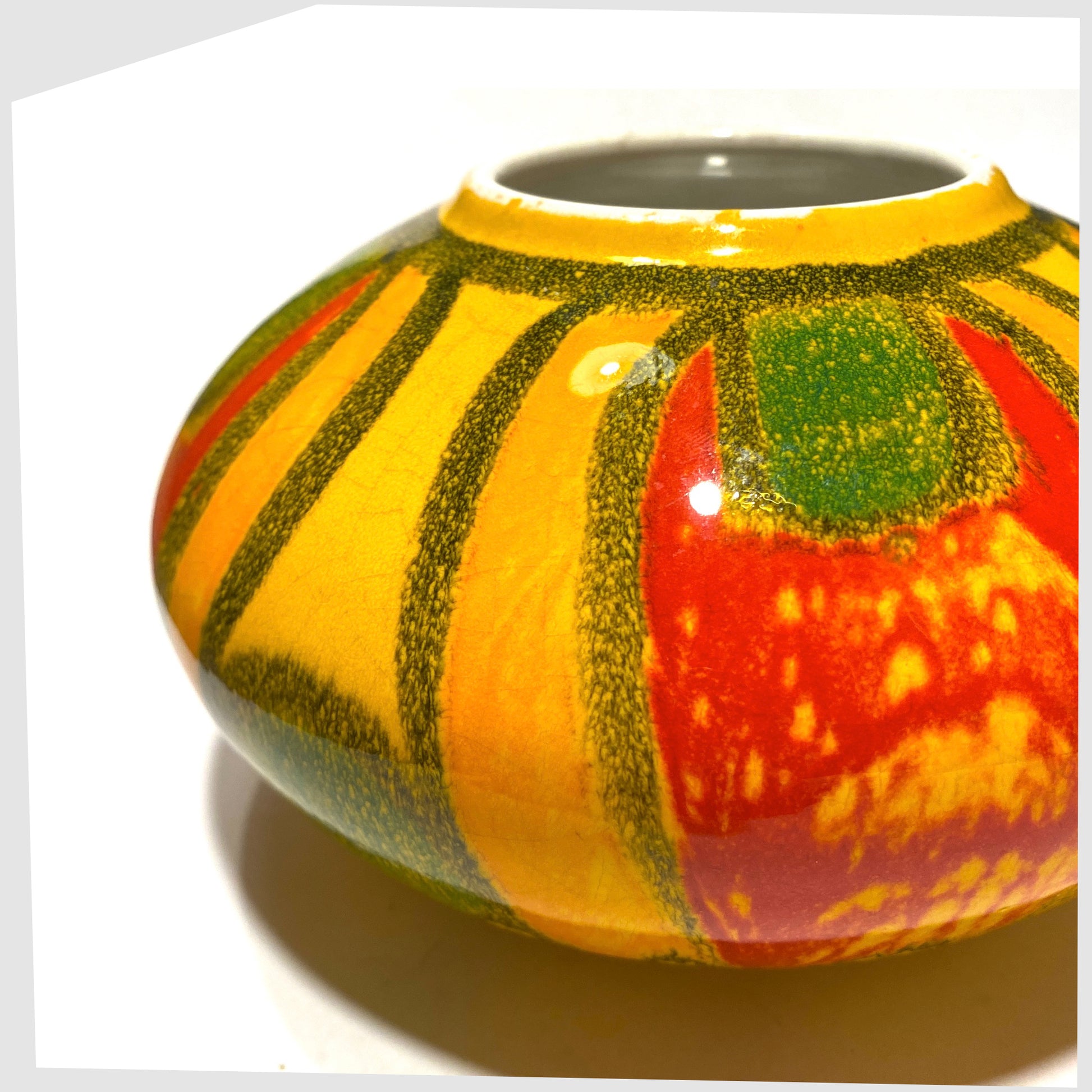 close up of the Poole Pottery Onion Vase, Shape 32, by Gillian Taylor in a vivid yellow glaze with abstract forms of orange, red and green