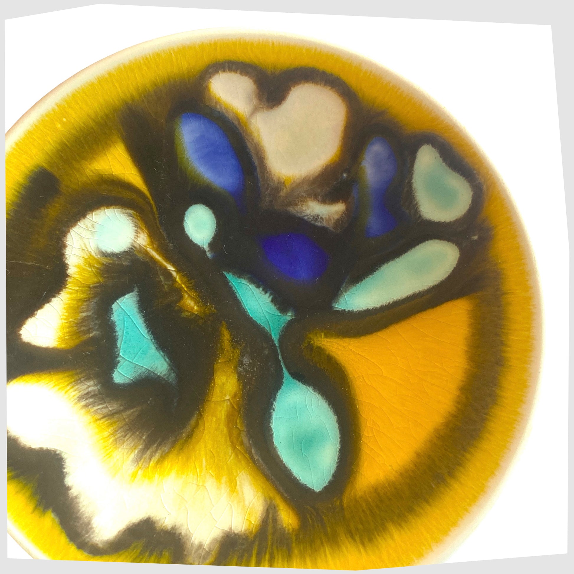 Close up of the Poole Pottery Delphis Pin Dish, Shape 49, in a yellow glaze with fluid forms of turquoise and blue, created by Carol Cutler