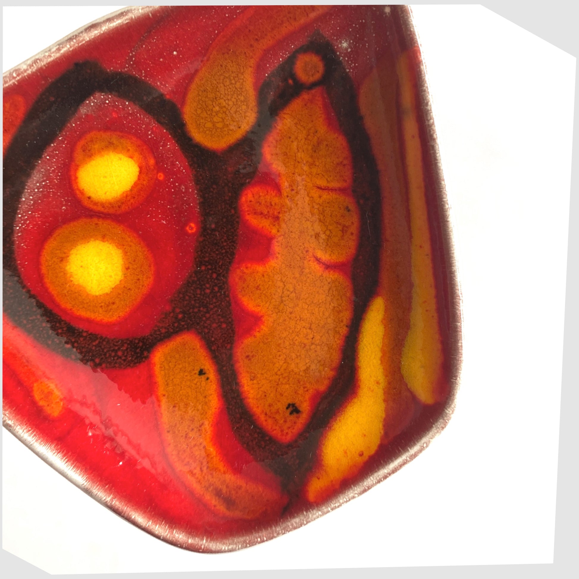 glazing detail of the Poole Pottery Delphis Pin Dish, shape 41, by Loretta Leigh glazed in a rich red with fluid forms of blue, orange and yellow