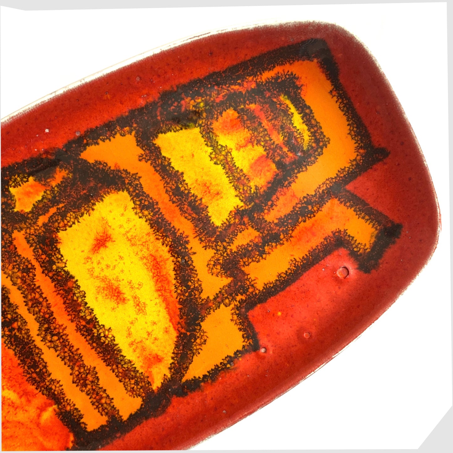 close up of the poole pottery delphis pin dish, shape 361, by Carol Cutler in a vivid red, yellow and orange glaze