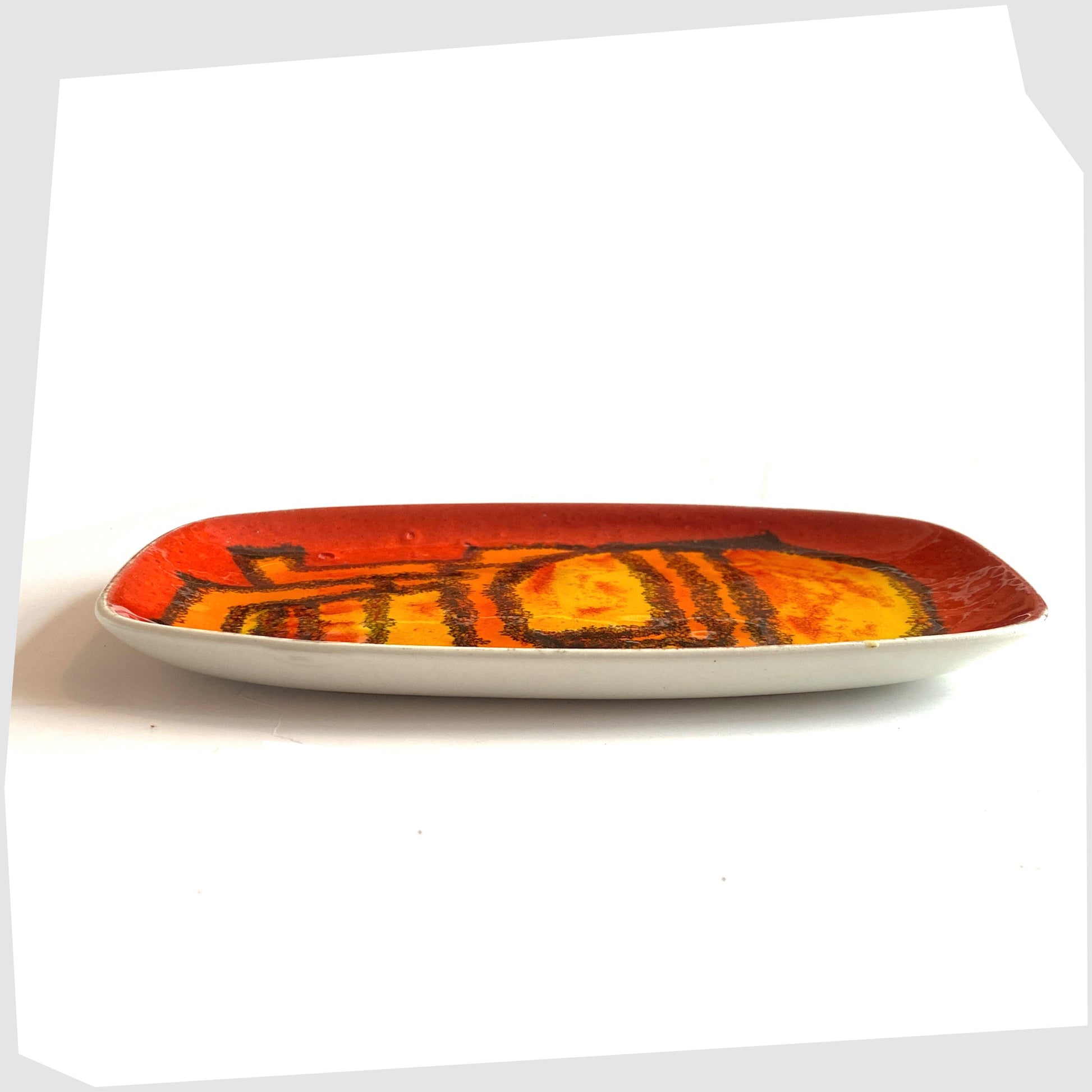 side profile of the poole pottery delphis pin dish, shape 361, by Carol Cutler in a vivid red, yellow and orange glaze
