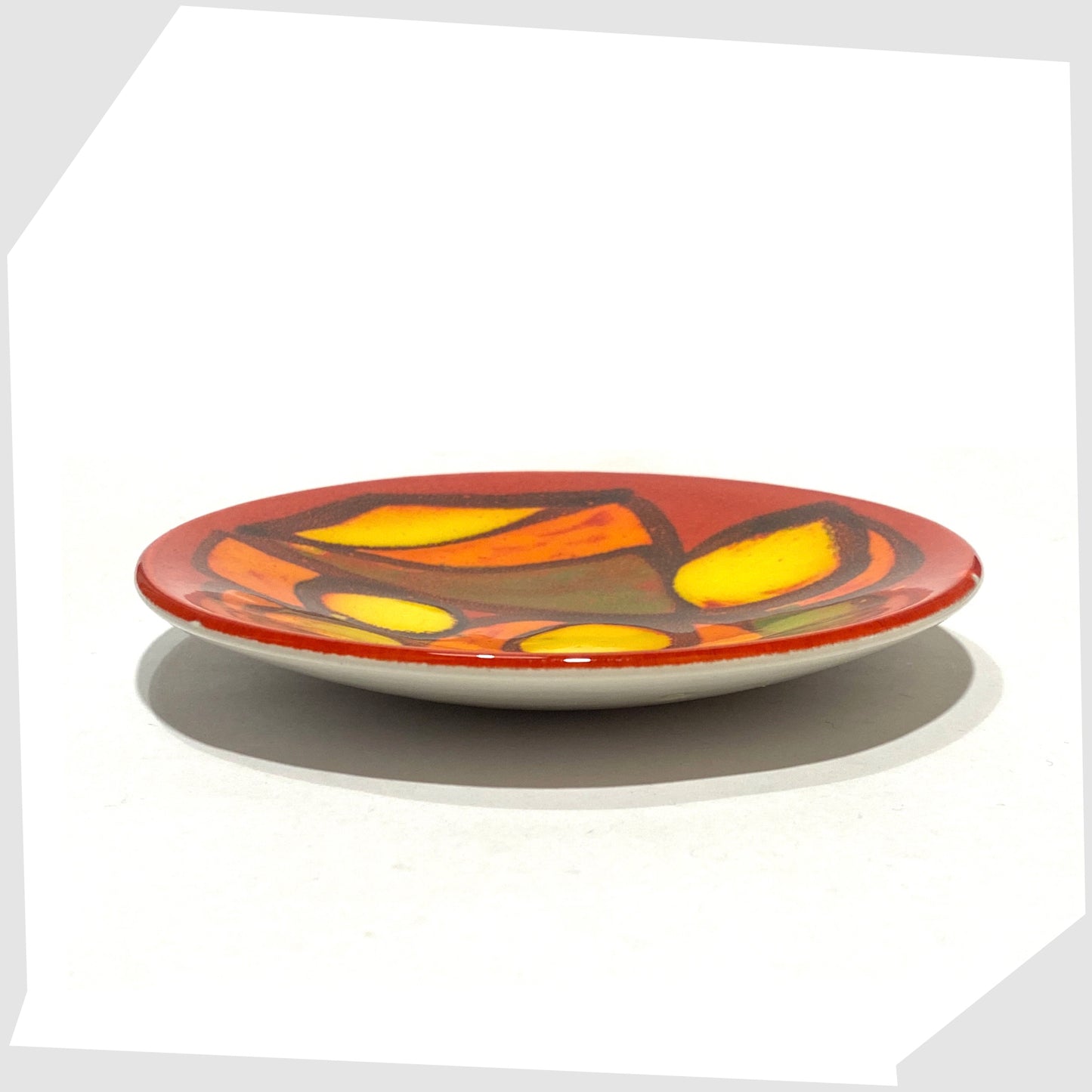 side profile of the Poole Pottery Delphis Pin Dish, by Gillian Taylor, finished in a rich red with free forms of orange and green