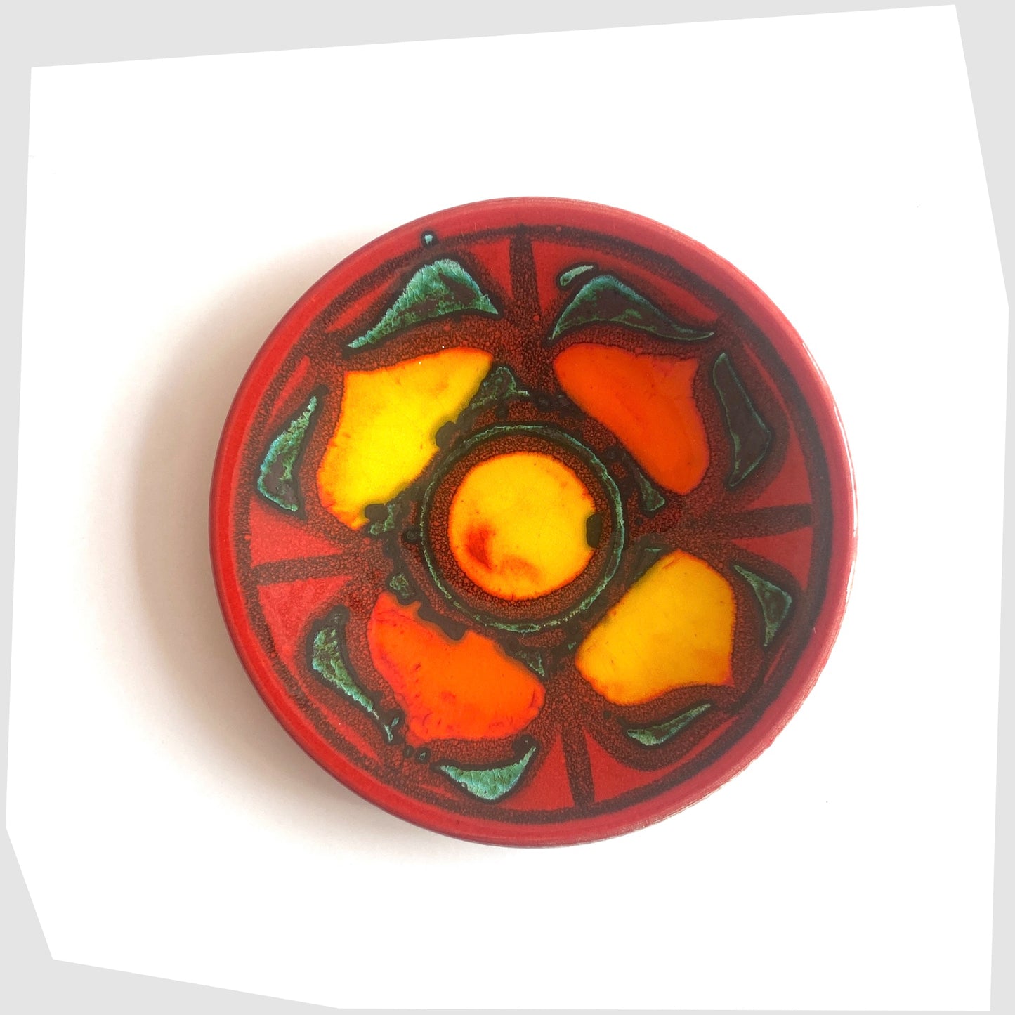 Poole Pottery Delphis Pin Dish by Janet Laird in a vibrant red glaze with radiating forms of rich yellow and green, shown on a white background